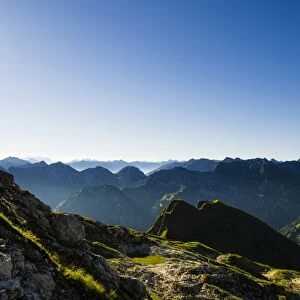 Peaks of the Allgau Alps in steplike arrangement in the early morning with a sun star, Oberstdorf, Bavaria, Germany