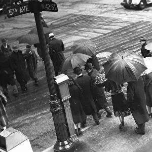 People crossing street in rain, (B&W), elevated view