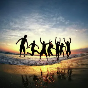 People jumping on beach at sunset in Costa Rica