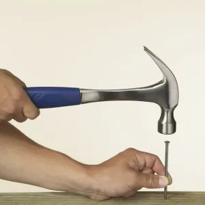 Person hitting nail into wood with hammer