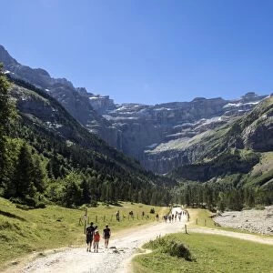 Persons walking along the cirque of Gavarnie. Pyrenees. France. World Heritage by UNESCO, the great waterfall