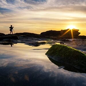 A photographer and sunset at Melasti beach, Bali