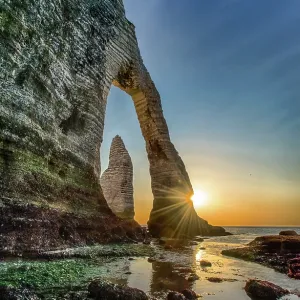 The Porte D'Aval rock formation in Etretat, France during the sunset The Porte D'Aval rock formation in Etretat, France during the sunset