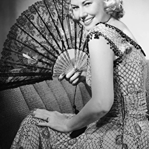 Portrait of blonde woman holding fan