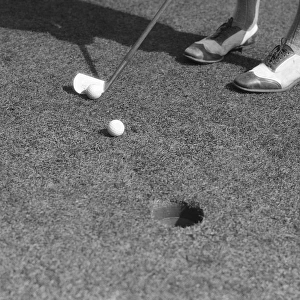 Putting Green With Feet In Golf Shoes In Upper Rig
