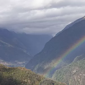 Rainbow over rural mountain valley
