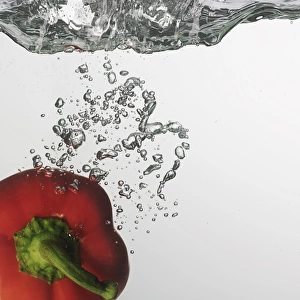Red capsicum falling into water
