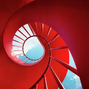Red spiral staircase against sky Red spiral staircase against sky