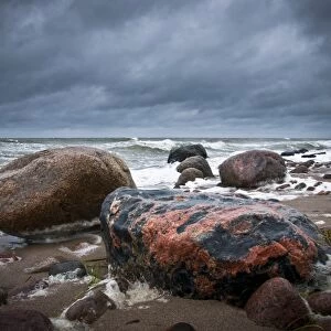 Reddish coloured boulders on the beach, a rough Baltic Sea at back, Rerik, Mecklenburg-Western Pomerania, Germany