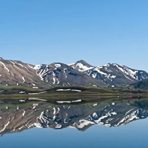 Reflection in the still lake, remnants of snow, panoramic mountain landscape at Alftavatn lake, Laugavegur trekking route, Highlands, Sudurland, Iceland