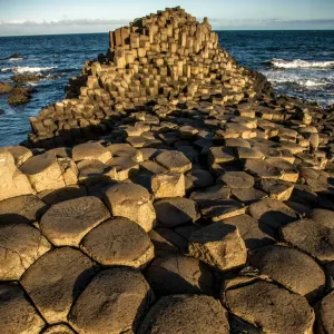 El sol naciente sobre una formación rocosa llamada Giants Causeway, condado de Antrim, Irlanda del Norte. El sol naciente sobre una formación rocosa llamada Giants Causeway, condado de Antrim, Irlanda del Norte.