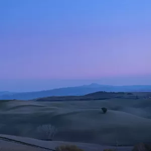 Rolling hill landscape of Val d Orcia after sunset