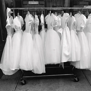 Row of white dresses hanging on rack