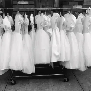 Row of white dresses hanging on rack Row of white dresses hanging on rack