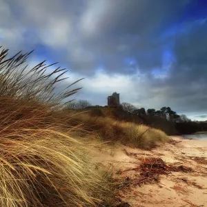 Ruined castle in sand dunes shore Ruined castle in sand dunes shore