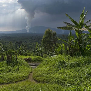 Rural dwelling with erupting Nyamuragira Volcano in background, Virunga National Park, Parq National des Virunga, Democratic Republic of Congo