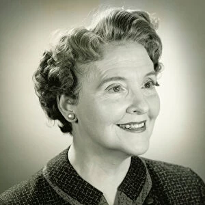 Senior woman smiling in studio, (B&W), close-up, portrait