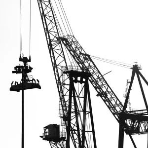 Silhouetted profile of construction cranes