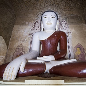 Sitting Buddha colored statue on a temple