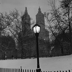 Small wooden fence and a lamppost in a snowy park