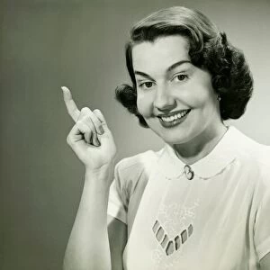 Smiling woman pointing finger in studio, (B&W), (Close-up), (Portrait)