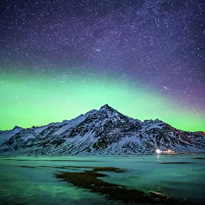 Snowy mountain with the aurora and milky way in Southern Iceland