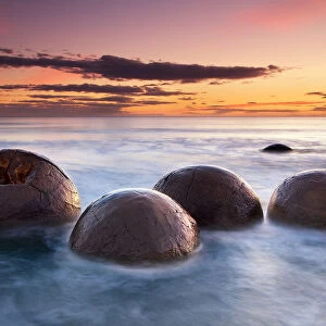Spherical boulders in the sea at sunrise