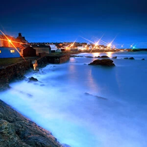 St Monans harbour lights at storm sea in night