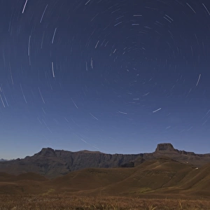 Star trails over the Amphitheatre range in the Drakensberg mountains, Kwazulu-Natal, South Africa