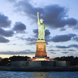 Statue of Liberty illuminated at dusk in New York