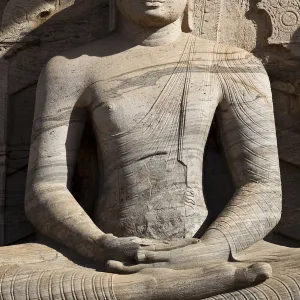 Statue of a sitting Buddha attached to the rock