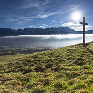 Summit cross of Gerenberg Mountain with high fog in front of the Alpstein Mountains, Gerenberg, Appenzell, Switzerland