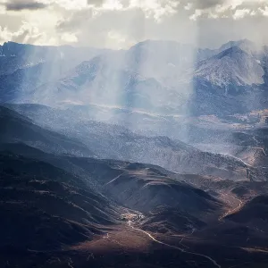 Sun shining above mountains and valleys