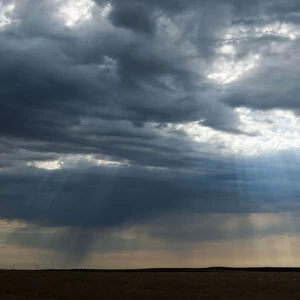 Sunlight breaking through dark clouds near Minuteman nuclear missile site, South Dakota, USA