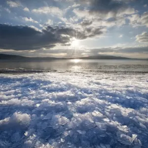 Sunlight with moody clouds, stacked ice floes on the shore of Reichenau Island, Baden-Wuerttemberg, Germany, Europe Sunlight with moody clouds, stacked ice floes on the shore of Reichenau Island, Baden-Wuerttemberg, Germany, Europe