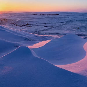 Sunrise over snow drifts in the English Peak District. UK