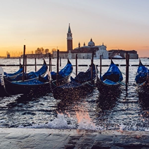 Sunrise view on gondola station near Piazza San Marco with Church of San Giorgio Maggiore on the backround during the rising tide