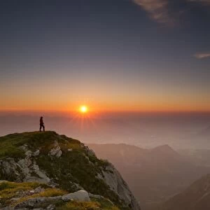 Sunset with hiker on a summit of the Allgau Alps, Oberstdorf, Bavaria, Germany