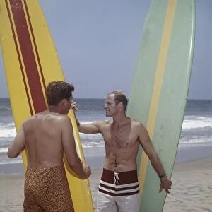 Surfers holding surfboards on beach