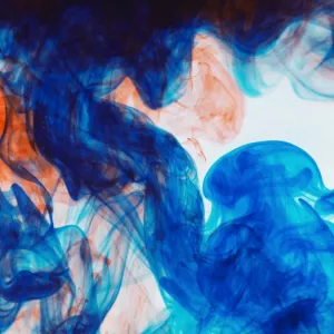 Swirls of orange and blue ink in liquid