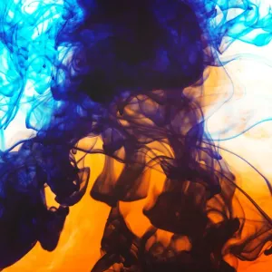 Swirls of spreading orange and blue ink in liquid Swirls of spreading orange and blue ink in liquid