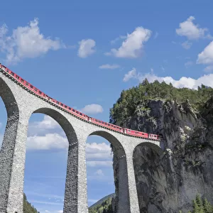 Switzerland, red train on a Viaduct