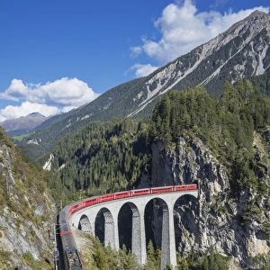 Switzerland, red train on a Viaduct