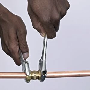 Tightening nuts to a compression joint attached to copper pipes using adjustable spanners