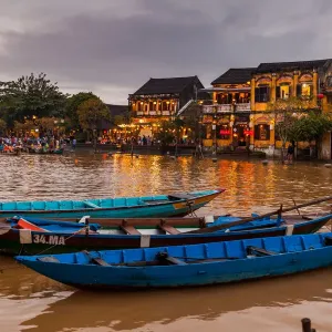 Traditional boats in front of ancient architecture in Hoi An, Vietnam