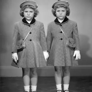 Twin girls in hats & coats wearing white gloves Twin girls in hats & coats wearing white gloves