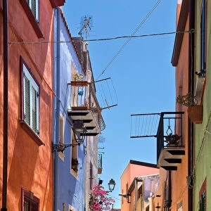 Uphill street with colourful architecture in Bosa, Sardinia, on a sunny day