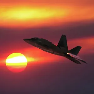 A USAF Lockheed Martin F-22A Raptor stealth fighter flying into the sunset A USAF Lockheed Martin F-22A Raptor stealth fighter flying into the sunset