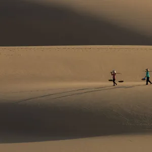 Vietnam - Two Vietnamese women with conical hat on sand dune