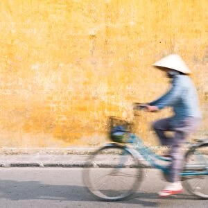 Vietnamese woman riding a bicycle in Hoi An